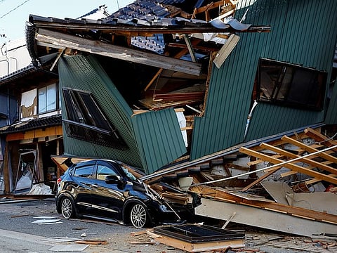 A damaged car stands near a collapsed house, following an earthquake, in Nanao, Ishikawa prefecture, Japan January 2, 2024.