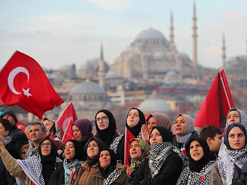 People gather over the Galata Bridge in solidarity with Palestinians, amid the ongoing conflict between Israel and the Palestinian Islamist group Hamas, following the first morning prayer of the New Year in Istanbul, on January 1, 2024. The Gaza war ended a gradual thawing in Turkish-Israeli relations that culminated with the reappointment of ambassadors in 2022.