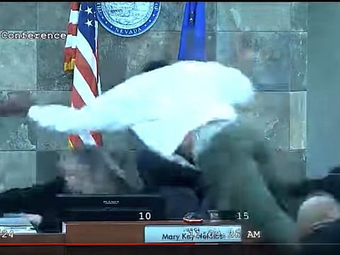 In this image from video provided by the Clark County District Court, a defendant identified by court officials and records as Deobra Redden is seen launching over the desk of Judge Mary Kay Holthus during his sentencing in a felony battery case on Wednesday, January 3, 2024 in Las Vegas.