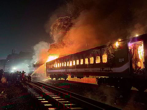 Firefighters try to extinguish a fire set to a passenger train ahead of the general election in Dhaka, Bangladesh, January 5, 2024.