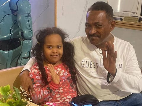 Nine-year-old girl who was found by Ajman Police, posing for a photograph with her father