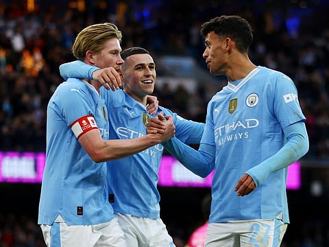 Manchester City's Kevin De Bruyne, Phil Foden and Matheus Nunes celebrates their fifth goal, scored by Jeremy Doku during the FA Cup third round match against Huddersfield Town at Etihad Stadium in Manchester on Sunday.