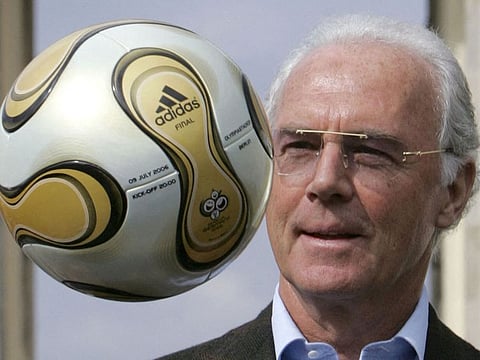 President of the Organising Committee of the 2006 FIFA Football World Cup Franz Beckenbauer throws up the football that will be used in the final of the World Cup during an unveiling ceremony in front of the Brandenburg Gate in Berlin 18 April 2006.