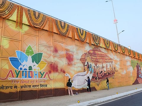 Artists make a wall painting of Lord Ram, Laxman, Bharat, Satrudhan, and Janaki sitting on a "Pushpaka Vimana" (chariots) near Valmiki International Airport, in Ayodhya on Tuesday