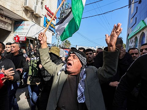 Palestinians shout slogans on January 9, 2024 during the funeral of three men killed during an overnight Israeli raid on the Tulkarem refugee camp in the occupied West Bank.