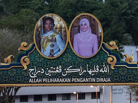 The portraits of groom Prince Abdul Mateen (L) and bride Anisha Rosnah (R) on a billboard over a road ahead of their wedding in Brunei.