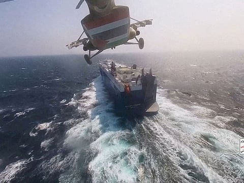 Houthi military helicopter flies over the Galaxy Leader cargo ship in the Red Sea.