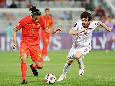 Tajikistan's defender Vakhdat Khanonov (right) vies for the ball against China's forward Zhang Yuning during their 2023 AFC Asian Cup Group A football match at the Abdullah bin Khalifa Stadium in Doha on January 13, 2024.