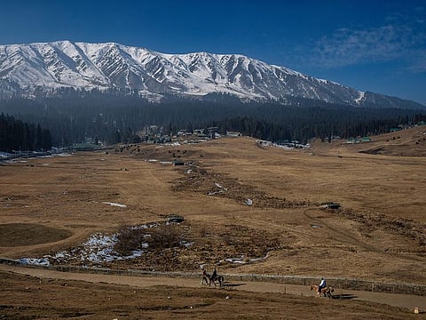 Tourists take a horse ride on grassy, snowless ski slopes in Gulmarg, northwest of Srinagar, on January 13, 2024. There is hardly any snow at Asia’s largest ski terrain in Gulmarg where thousands of domestic and international tourists would usually visit to ski and sledge its stunning snowscape in winter.