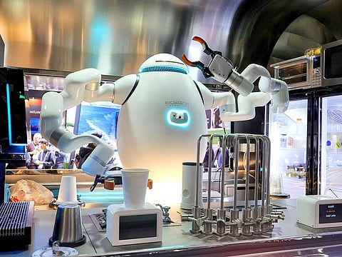 ADAM, an interactive robot bartender, barista and chef, makes drinks for attendees at the Richtech Robotics booth.