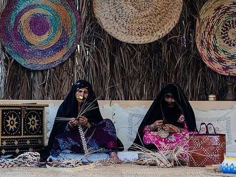 Emirati women making daily wares using parts of date palm trees at a previous edition of the festival