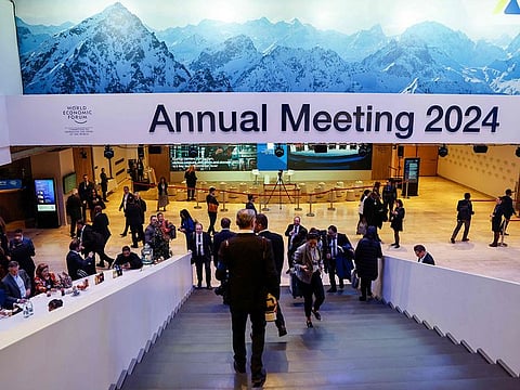 Participants use a staircase under signage which reads "Annual Meeting 2024" at the World Economic Forum (WEF) meeting in Davos on January 17, 2024.