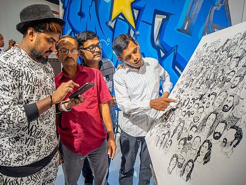 Doodle artist Sijin Gopinathan with his work Portraits of the People in the UAE in which he sketched black and white portraits of around 275 strangers.