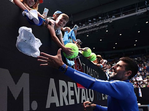 Serbia's Novak Djokovic signs autographs to fans after a victory against France's Adrian Mannarino during their men's singles match on Sunday.