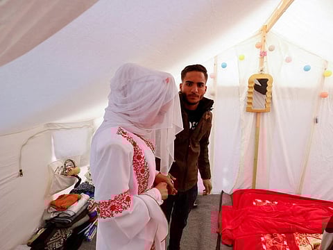 A Palestinian couple, Mohammed Al Ghandour and his bride Shahad, stands in a tent camp, amid the ongoing conflict between Israel and the Palestinian Islamist group Hamas on their wedding day, in Rafah in the southern Gaza Strip.