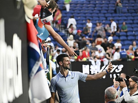 Serbia's Novak Djokovic poses for selfies with fans after his victory against USA's Taylor Fritz in their men's singles quarter-final match of the Australian Open in Melbourne on Monday.