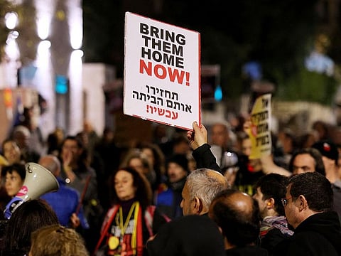 Protestors hold up signs during a rally organised by family and supporters of Israeli hostages held in Gaza since the October 7 attacks by Hamas in southern Israel, to demand their release, on January 22, 2024, near the residence of the Israeli prime minister in Jerusalem.