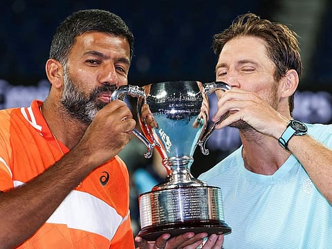 India's Rohan Bopanna (L) and Australia's Matthew Ebden celebrate with the trophy after victory against Italy's Simone Bolelli and Andrea Vavassori during their men's doubles final match on day 14 of the Australian Open tennis tournament in Melbourne on January 27, 2024.