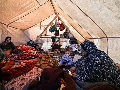 Members of a displaced Palestinian family sit inside a tent at a makeshift camp in Rafah in the southern Gaza