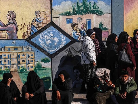 Displaced Palestinians queue to receive aid in front of the United Nations Relief and Works Agency for Palestine Refugees (UNRWA) centre in Rafah in the southern Gaza Strip on January 28, 2024.