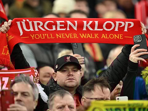 A fan holds a tribute to Liverpool's German manager Jurgen Klopp ahead of the English FA Cup fourth round football match against Norwich City at Anfield in Liverpool, north west England on Sunday.