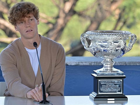 Italian Jannik Sinner sits close to his trophy during a press conference after his victory at the Australian Open on Wednesday.