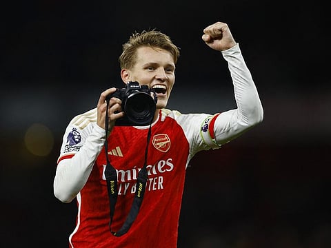 Arsenal's Martin Odegaard celebrates with a camera after the match.