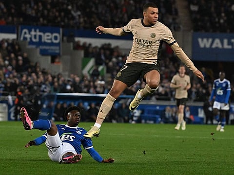 Strasbourg's Ivorian defender Abakar Sylla (left) and Paris Saint-Germain's French forward Kylian Mbappe compete in the L1 match at the Meinau stadium in Strasbourg, on February 2.