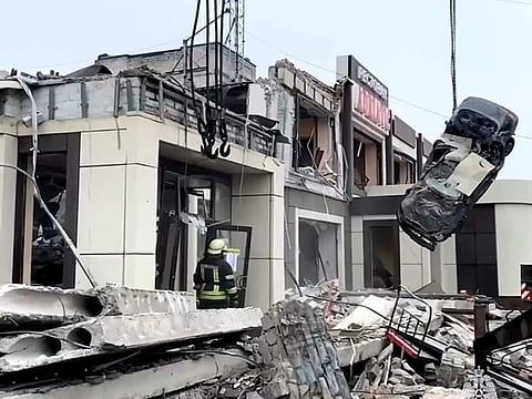 Russian Emergency Ministry employees work at the side of a collapsed bakery after an attack of Ukrainian troops.