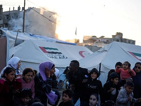 Displaced Palestinians react near their tents following an Israeli strike on a car, amid the ongoing conflict between Israel and the Palestinian Islamist group Hamas, in Rafah, in the southern Gaza Strip, February 7, 2024.