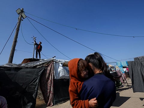 Displaced Palestinian teenager Hussam Al Attar, nicknamed by people 'Newton', works on wind turbines, that he uses to light up his shelter during power cut, at a tent camp in Rafah, in the southern Gaza Strip, February 6, 2024.