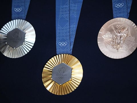 The Chaumet-designed Paris 2024 Olympic gold, silver and bronze medals, featuring a hexagon-shaped piece of iron taken from the original Eiffel Tower, unveiled at the event headquarters in Paris, France, on Thursday.