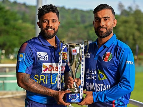 Sri Lanka's captain Kusal Mendis (left) and Afghanistan's captain Hashmatullah Shahidi pose with the ODI trophy at the Pallekele International Cricket Stadium in Kandy on Thursday.