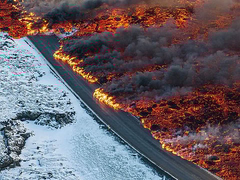 A view of lava crossing the main road to Grindavík and flowing on the road leading to the Blue Lagoon, in Grindavík, Iceland
