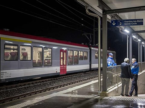 Swiss police officers stand next to a train, where passengers travelling from Yverdon to Sainte-Croix were earlier held hostage, in Essert-Sous-Champvent, western Switzerland on February 8, 2024.