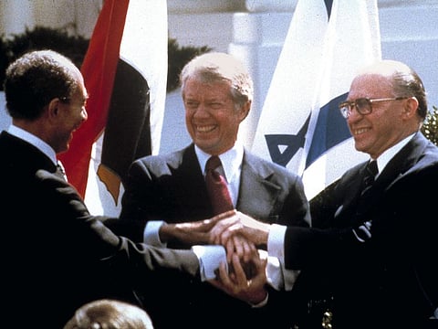 Egyptian President Anwar Sadat, left, US President Jimmy Carter, and Israeli Prime Minister Menachem Begin (right) clasp hands on the North lawn of the White House as they completed signing of the peace treaty between Egypt and Israel in Washington on March, 26, 1979.