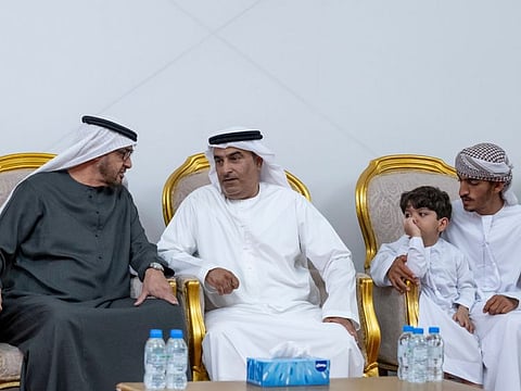 President His Highness Sheikh Mohamed bin Zayed Al Nahyan (L), offers condolences to the family and friends of martyr First Warrant Officer Khalifa Al Baloushi, during his visit to the condolence majlis in Ajman on Tuesday
