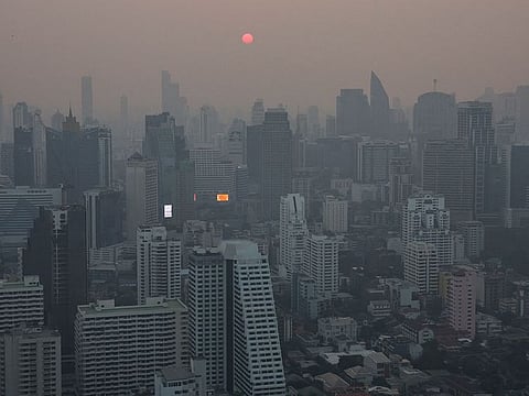 A view of the city amid air pollution during sunrise in Bangkok, Thailand.