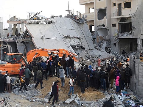 Palestinians look at the destruction after an Israeli strike on a residential building in Rafah, Gaza Strip, Friday, Feb. 16, 2024.