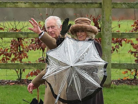 Britain's King Charles and Queen Camilla walk after attending a church service at St. Mary Magdalene's church.