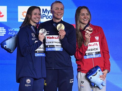 From left: US' silver-medallist Kate Douglass, Sweden's gold-medallist Sarah Sjoestroem and Poland's bronze-medallist Katarzyna Wasick pose on the podium of the women's 50m freestyle swimming event during the 2024 World Aquatics Championships at Aspire Dome in Doha on Sunday.