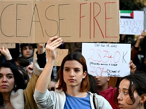 A woman holds a placard as she and others demonstarte during a 'Protest for Palestine' and in front of the Italian national television headquarters RAI, in central Rome on February 17, 2024.