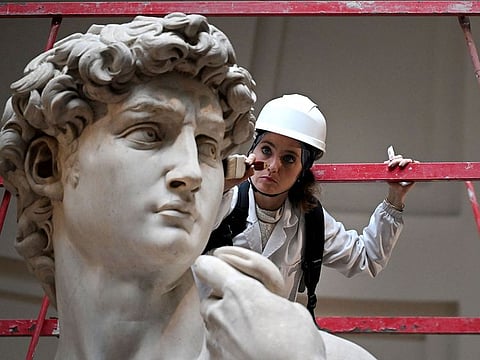 Italian restorer Eleonora Pucci cleans Michelangelo's statue of David using a backpack vacuum and synthetic fibre brush at the Galleria dell'Accademia, in Florence.