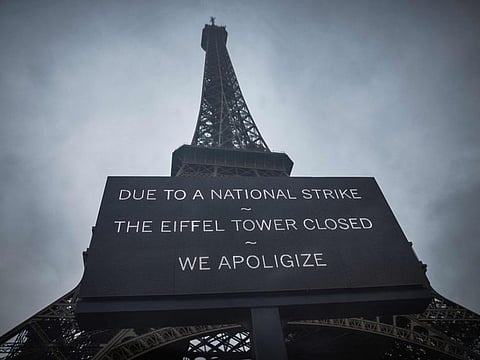 A board informs visitors that the Eiffel Tower is closed during the second week of the French school holidays.