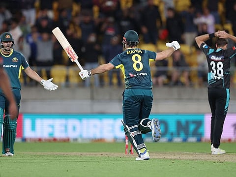 Australia's captain Mitchell Marsh celebrates his team's win with teammate Tim David (left) as New Zealand's Tim Southee reacts in the first Twenty20 international cricket match at Sky Stadium in Wellington on Wednesday.
