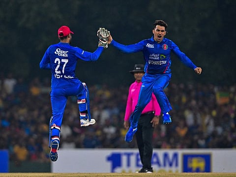 Afghanistan's Rahmanullah Gurbaz (right) celebrates with Afghanistan's wicketkeeper Mohammad Ishaq after taking the wicket of Sri Lankan batter Dasun Shanaka during the third and final Twenty20 international cricket match at The Rangiri Dambulla International Cricket Stadium in Dambulla on Wednesday.