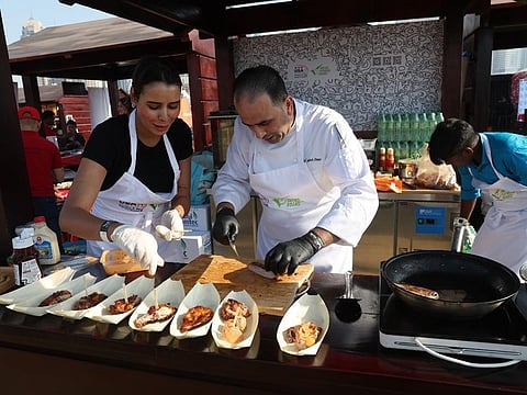 Chefs preparing food for visitors at Taste of Dubai.