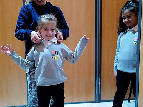 Schoolchildren try on the new school uniforms, which will be used in some elementary schools of the Beziers city at the Palais des Congres in Beziers, southern France.