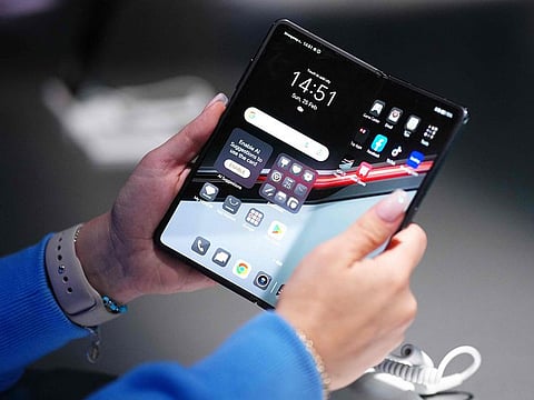 A woman holds the new Honor Magic V2 RSR smartphone, a device with the partnership of the German cars manufacturer Porsche, during a presentation on the eve of the Mobile World Congress (MWC), the telecom industry's biggest annual gathering, in Barcelona.