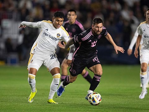 Inter Miami forward Lionel Messi dribbles the ball past Los Angeles Galaxy midfielder Edwin Cerrillo (20) during the first half of an MLS soccer match on Sunday.